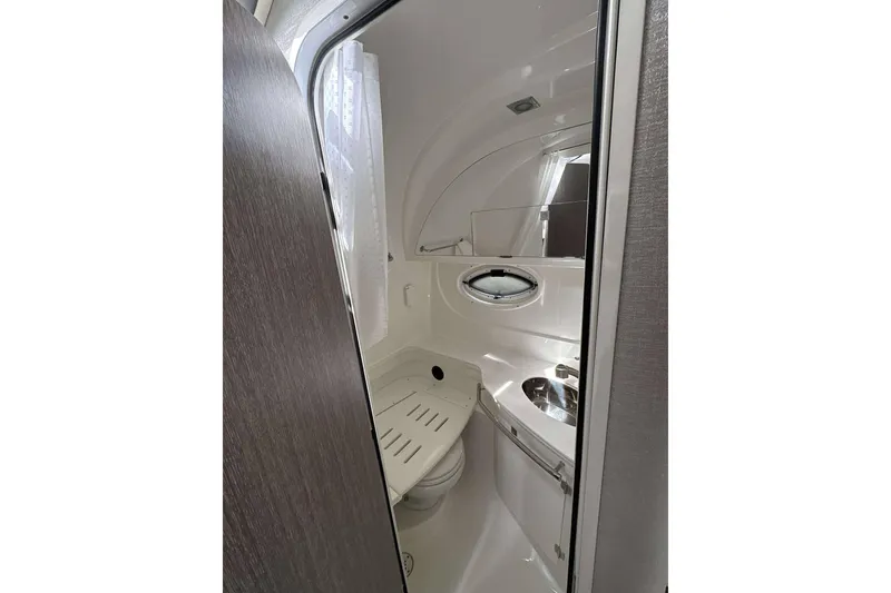 Slide: The Image of 2020 Monterey 355 Sport Yacht bathroom interior with modern fixtures and porthole window. - 20
