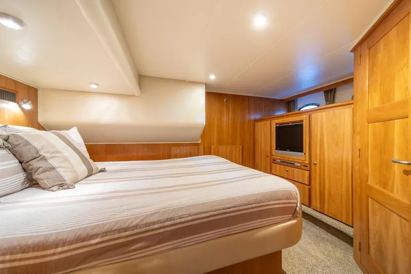 Slide: The Image of Luxurious bedroom interior of 2007 Navigator Classic 48 yacht with wood paneling and cozy bedding. - 20