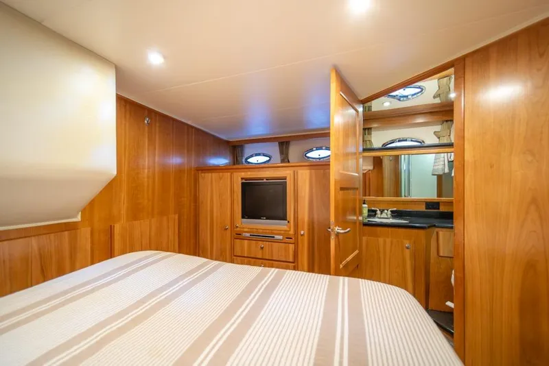 Slide: The Image of Luxurious 2007 Navigator Classic 48 yacht bedroom with wood paneling and ensuite bathroom. - 21