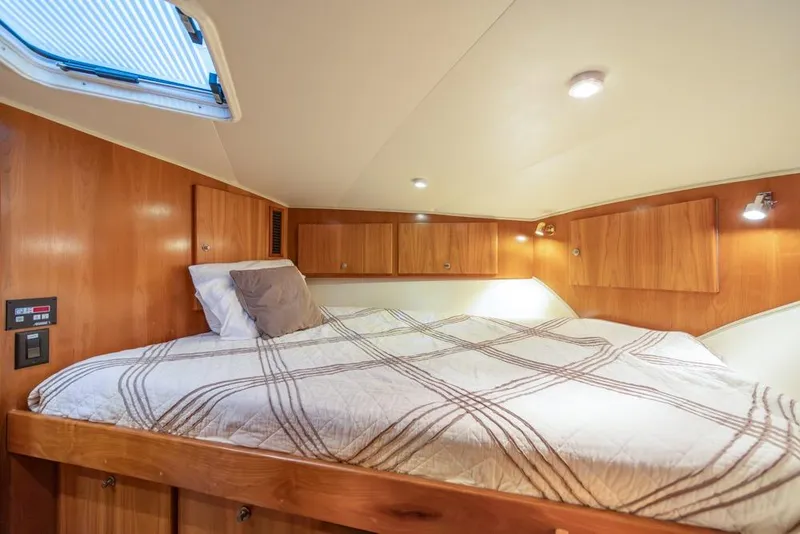 Slide: The Image of Cozy cabin bedroom in 2007 Navigator Classic 48 yacht with wood paneling and skylight. - 26