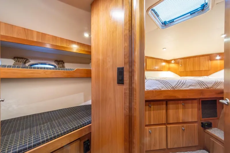Slide: The Image of 2007 Navigator Classic 48 yacht interior with cozy wooden bunk beds and a well-lit cabin. - 28