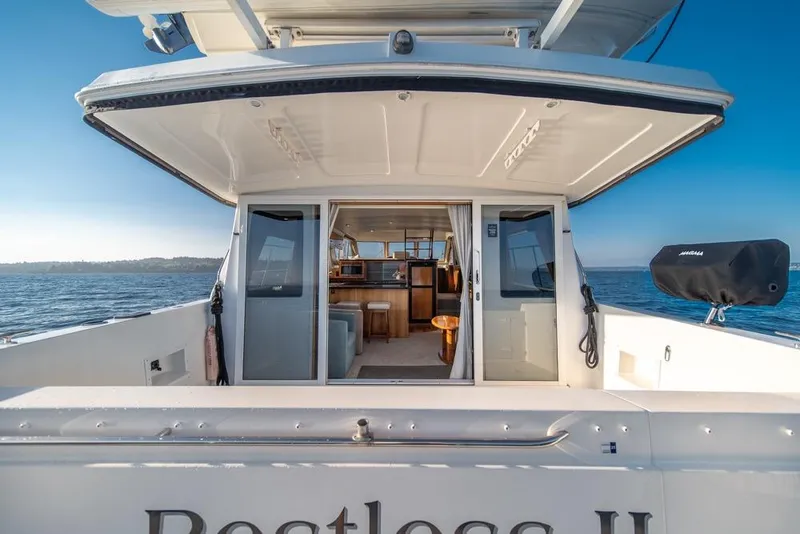 Slide: The Image of 2007 Navigator Classic 48 yacht interior view with open doors, ocean backdrop. - 37