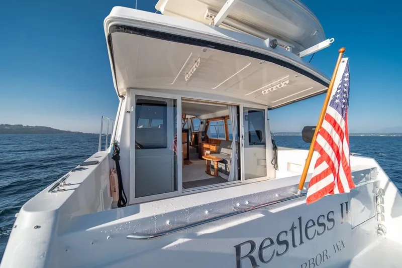 Slide: The Image of 2007 Navigator Classic 48 yacht with American flag, open cabin, and ocean view. - 38