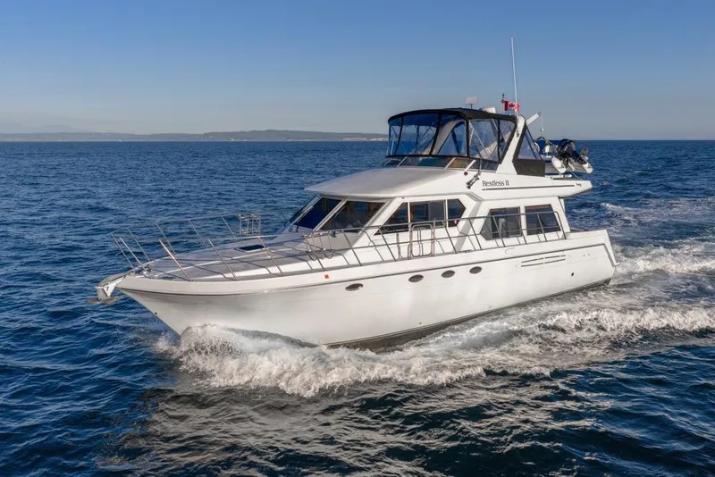 Slide: The Image of 2007 Navigator Classic 48 yacht cruising on open sea under clear blue sky. - 4