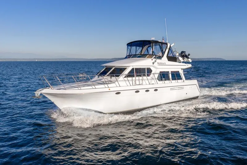 Slide: The Image of 2007 Navigator Classic 48 yacht cruising on open water under clear blue skies. - 49