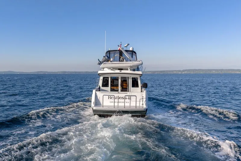 Slide: The Image of 2007 Navigator Classic 48 yacht cruising on open water under clear blue skies. - 5