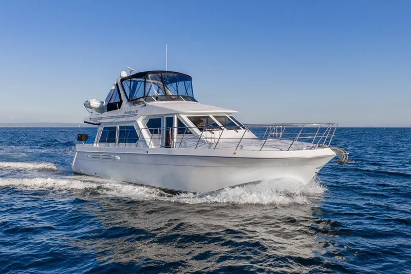 Slide: The Image of 2007 Navigator Classic 48 yacht cruising on open sea under clear blue sky. - 50