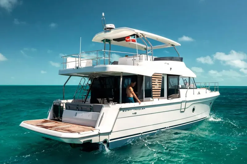 The Image of 2026 Beneteau Swift Trawler 48 cruising on clear turquoise waters under a sunny sky. - 1