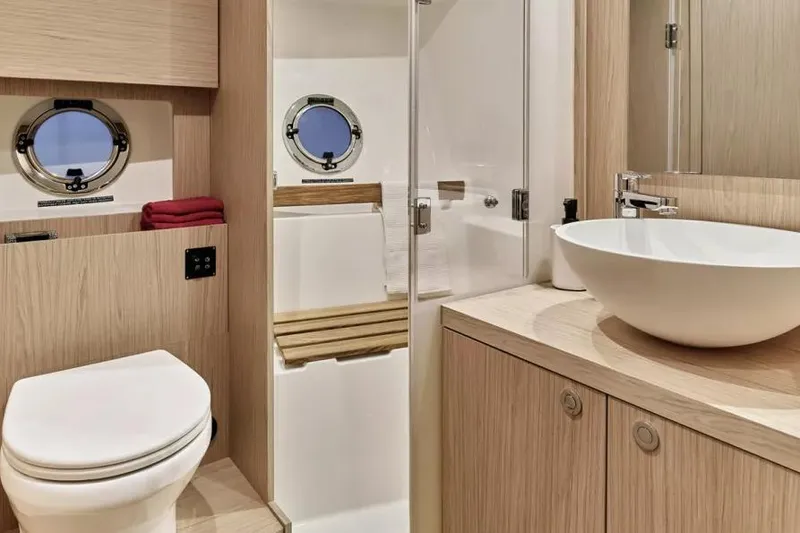 Slide: The Image of Luxurious bathroom in 2026 Beneteau Swift Trawler 48 with modern fixtures and porthole windows. - 10