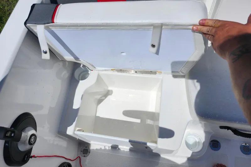 Slide: The Image of 2023 Tahoe T18 boat storage compartment with open lid and cup holders. - 11