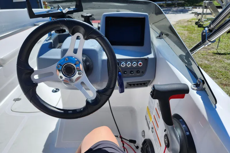Slide: The Image of 2023 Tahoe T18 boat cockpit with steering wheel, control panel, and throttle lever. - 12