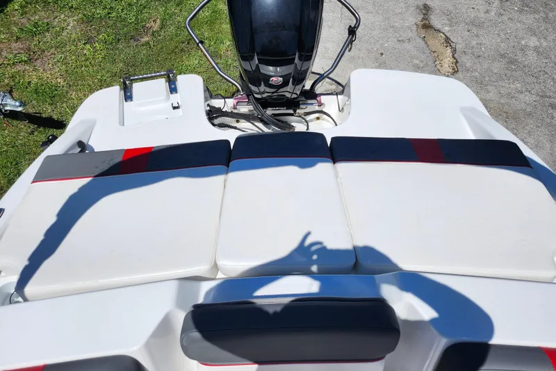 Slide: The Image of 2023 Tahoe T18 boat with cushioned seating and outboard motor, parked on grass. - 15