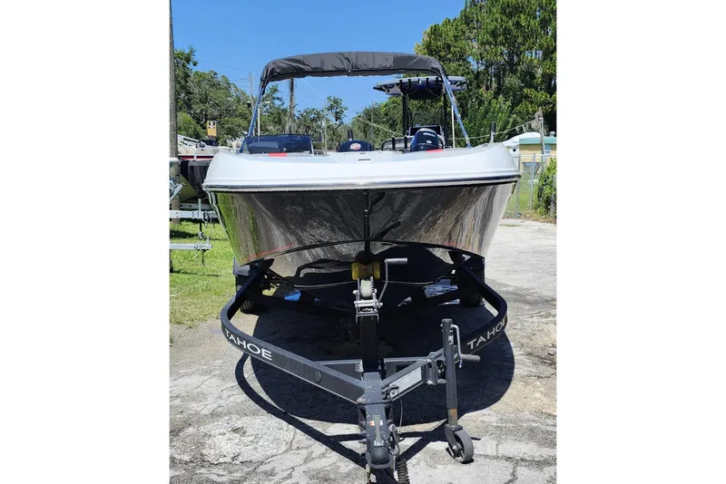 Slide: The Image of 2023 Tahoe T18 boat on trailer, parked outdoors, front view. - 2