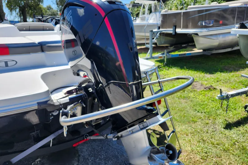 Slide: The Image of 2023 Tahoe T18 boat with outboard motor, displayed outdoors on grass. - 22
