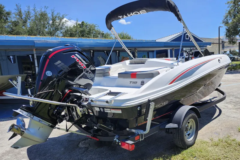 Slide: The Image of 2023 Tahoe T18 boat with outboard motor on trailer, parked outdoors. - 5