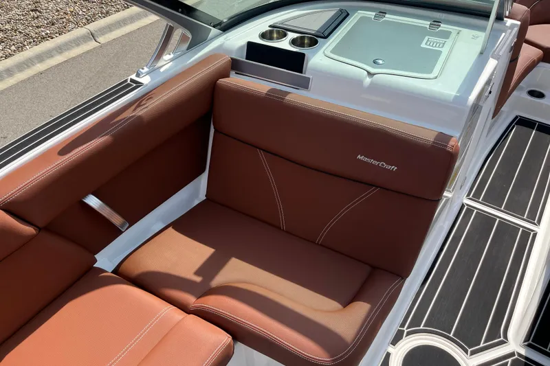 Slide: The Image of 2020 MasterCraft XT23 boat interior with brown leather seating and cup holders. - 11