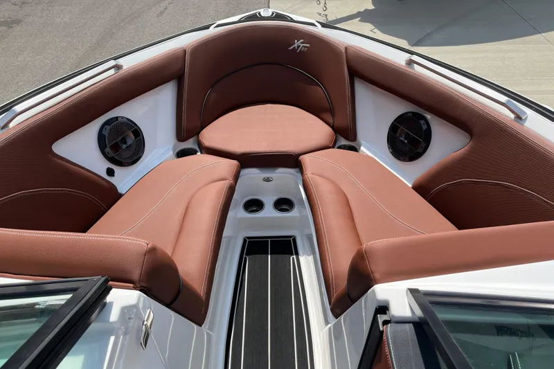 Slide: The Image of 2020 MasterCraft XT23 boat interior with brown seating and built-in speakers. - 12