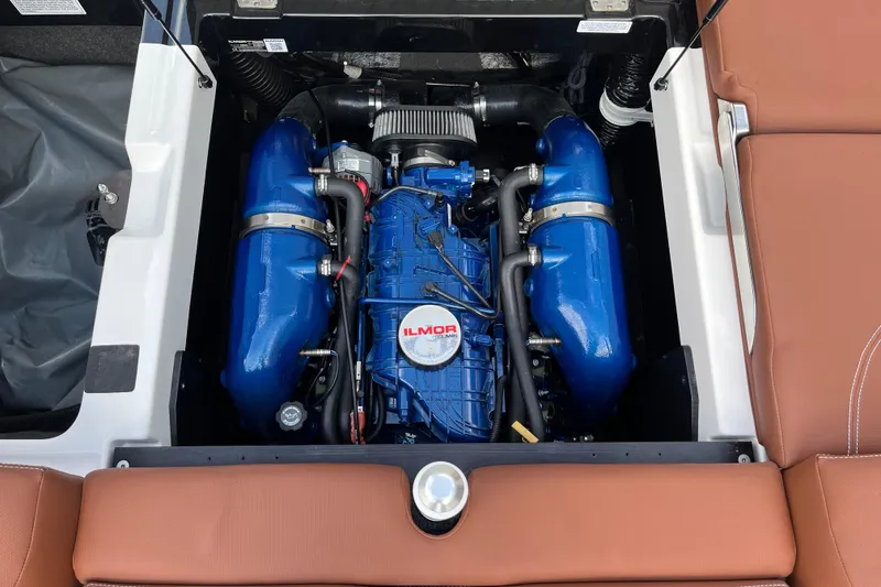 Slide: The Image of 2020 MasterCraft XT23 engine compartment with Ilmor marine engine, featuring blue components and brown seating. - 15