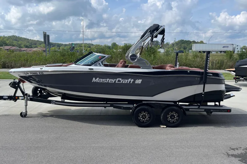 Slide: The Image of 2020 MasterCraft XT23 boat on trailer, parked outdoors under cloudy sky. - 5