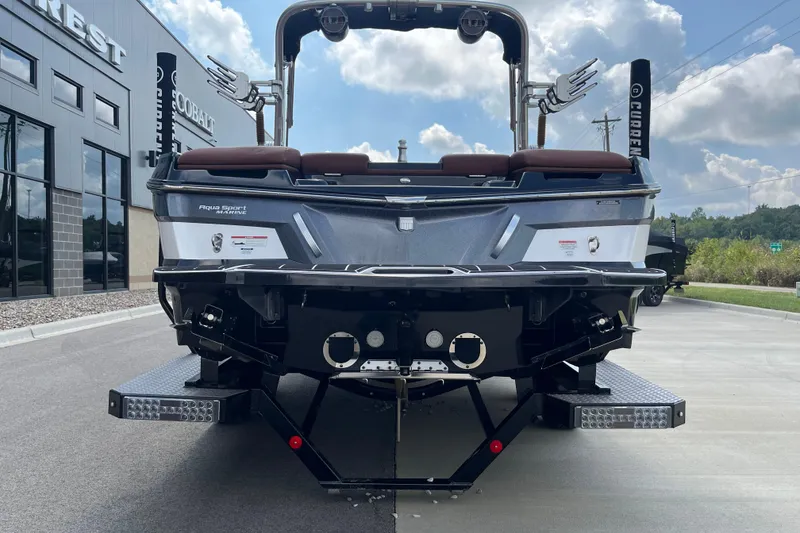 Slide: The Image of 2020 MasterCraft XT23 boat rear view, parked outdoors under a cloudy sky. - 7