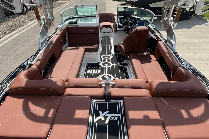 Slide: The Image of 2020 MasterCraft XT23 boat interior with brown leather seating and sleek design. - 9