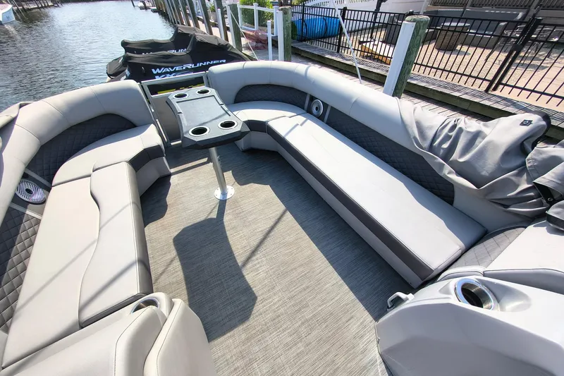 Slide: The Image of Luxurious seating area on a 2023 Bennington 25 LSRC pontoon boat with table and cup holders. - 11