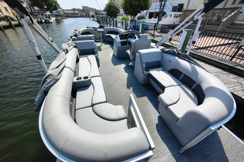 Slide: The Image of 2023 Bennington 25 LSRC pontoon boat with spacious seating and modern design on a calm waterway. - 4