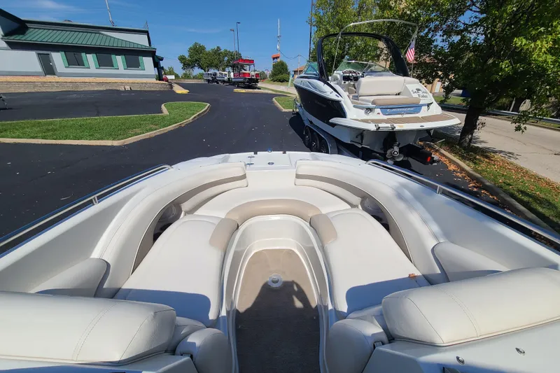 Slide: The Image of 2007 Crownline 252 EX boat with spacious seating, parked outdoors on a sunny day. - 12