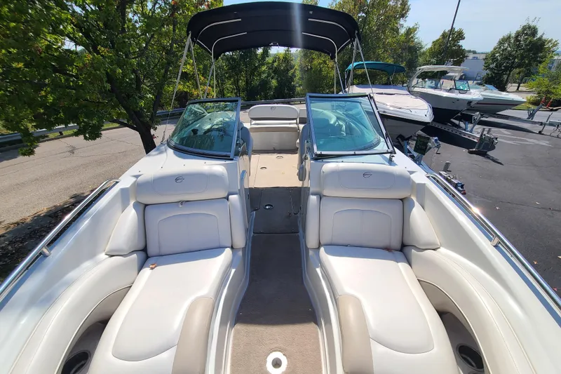Slide: The Image of 2007 Crownline 252 EX boat with white seating and canopy, parked outdoors. - 13