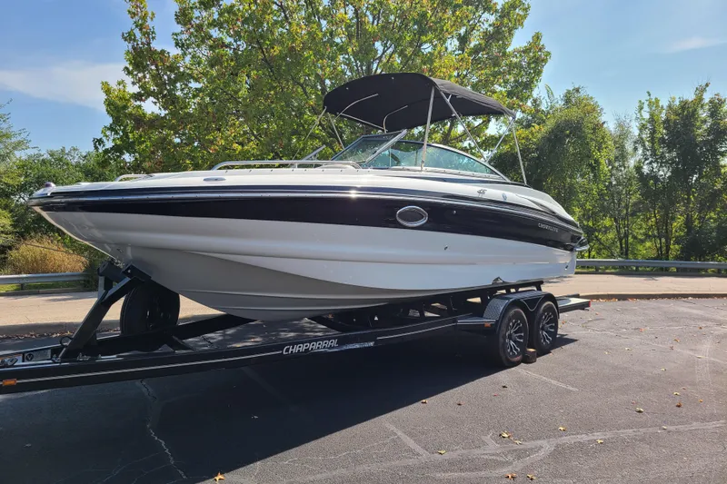 Slide: The Image of 2007 Crownline 252 EX boat on trailer, parked outdoors with trees in background. - 2