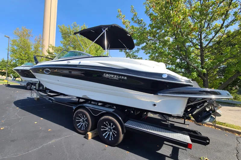 Slide: The Image of 2007 Crownline 252 EX boat on trailer, black and white design, parked outdoors. - 3