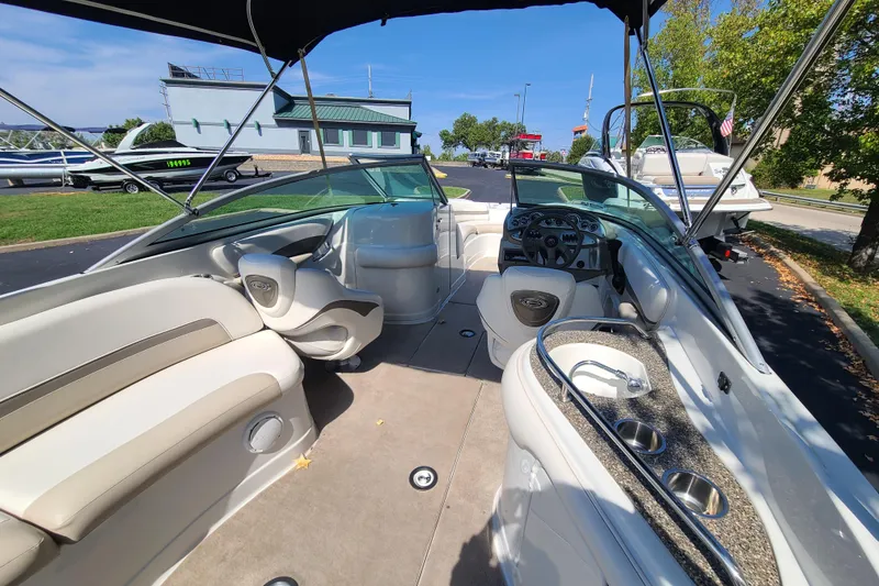 Slide: The Image of 2007 Crownline 252 EX boat interior with seating, steering, and cup holders under a canopy. - 5