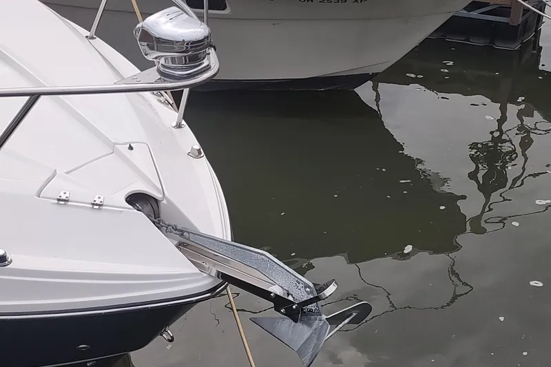 Slide: The Image of 2017 Rinker EX 320 boat with anchor, docked on calm water. - 11