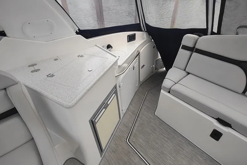 Slide: The Image of 2017 Rinker EX 320 boat interior with seating and kitchenette area. - 16