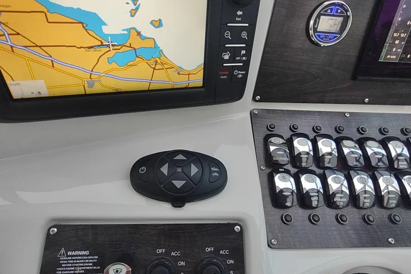 Slide: The Image of Control panel of a 2017 Rinker EX 320 boat with navigation display and switches. - 24