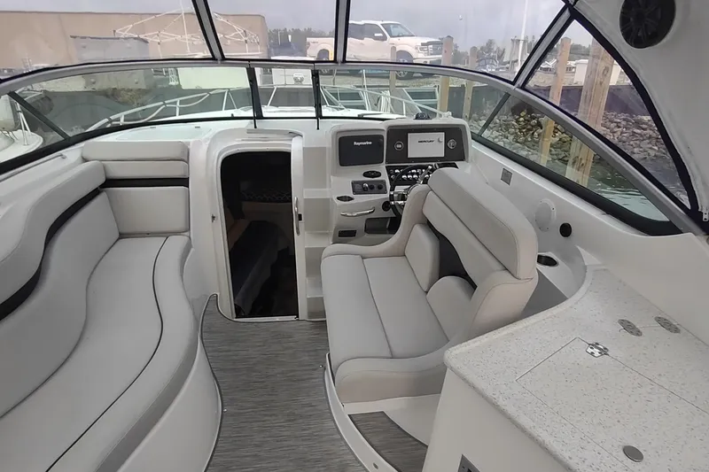 Slide: The Image of 2017 Rinker EX 320 boat interior with helm, seating, and cabin entrance. - 29