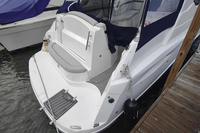 Slide: The Image of 2017 Rinker EX 320 boat docked, featuring a spacious rear deck and seating area. - 31