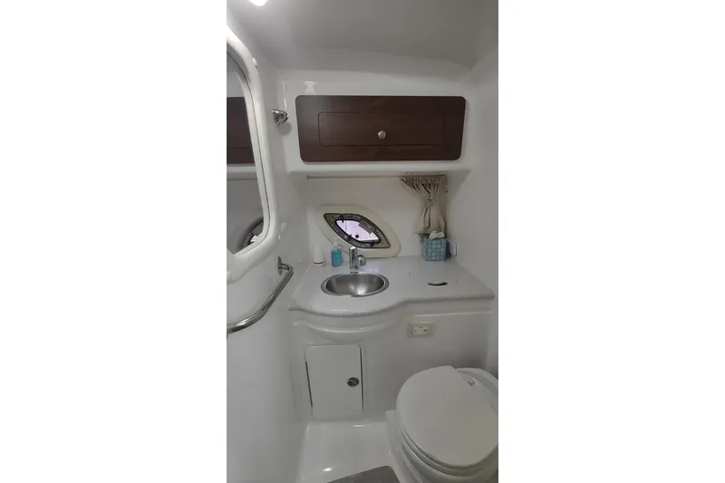 Slide: The Image of 2017 Rinker EX 320 boat bathroom with sink, toilet, and storage cabinet. - 33