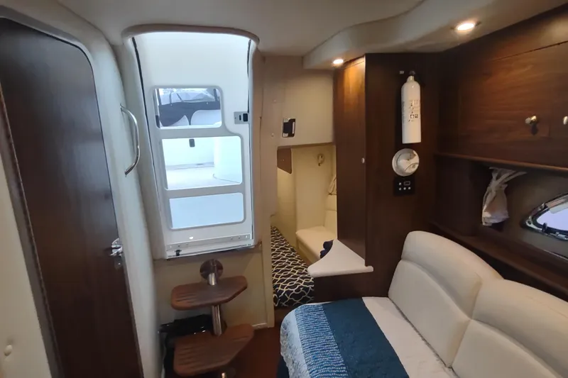 Slide: The Image of 2017 Rinker EX 320 cabin interior with seating, wooden accents, and modern amenities. - 35