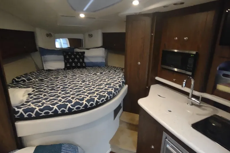 Slide: The Image of 2017 Rinker EX 320 cabin interior with bed, kitchenette, and microwave. - 39