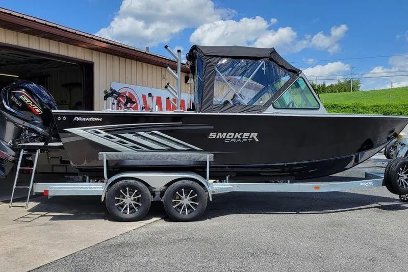 Slide: The Image of 2025 Smoker Craft Phantom 20 X2 OS boat on trailer, parked outdoors under blue sky. - 1