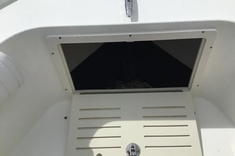 Slide: The Image of Open storage compartment on 2016 Mako 284 Center Console boat. - 11