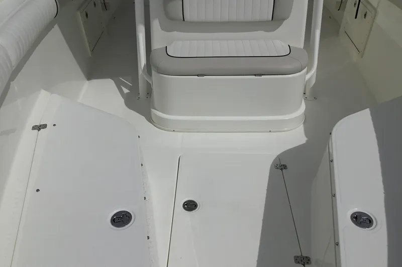 Slide: The Image of 2016 Mako 284 Center Console boat interior with seating and storage compartments. - 13
