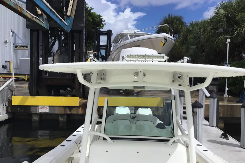 Slide: The Image of 2016 Mako 284 Center Console boat docked near a marina lift. - 15