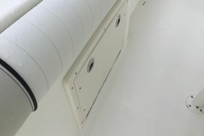 Slide: The Image of 2016 Mako 284 Center Console boat interior with storage compartment and cushioned seating. - 16