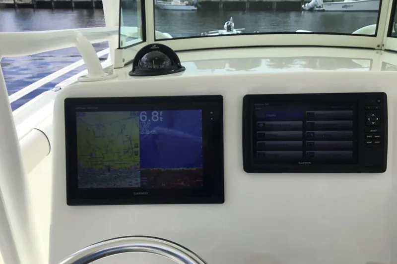 Slide: The Image of 2016 Mako 284 Center Console with Garmin navigation displays and compass. - 20