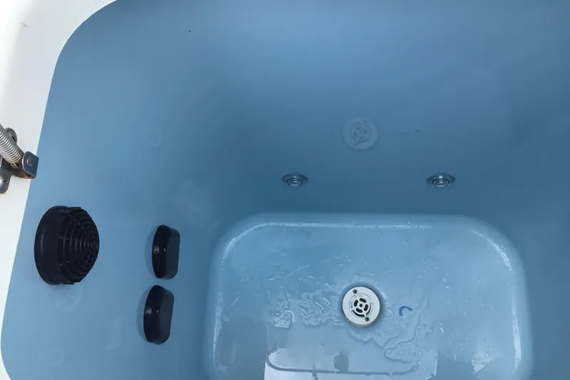 Slide: The Image of Livewell interior of 2016 Mako 284 Center Console boat, featuring drain and aeration system. - 24