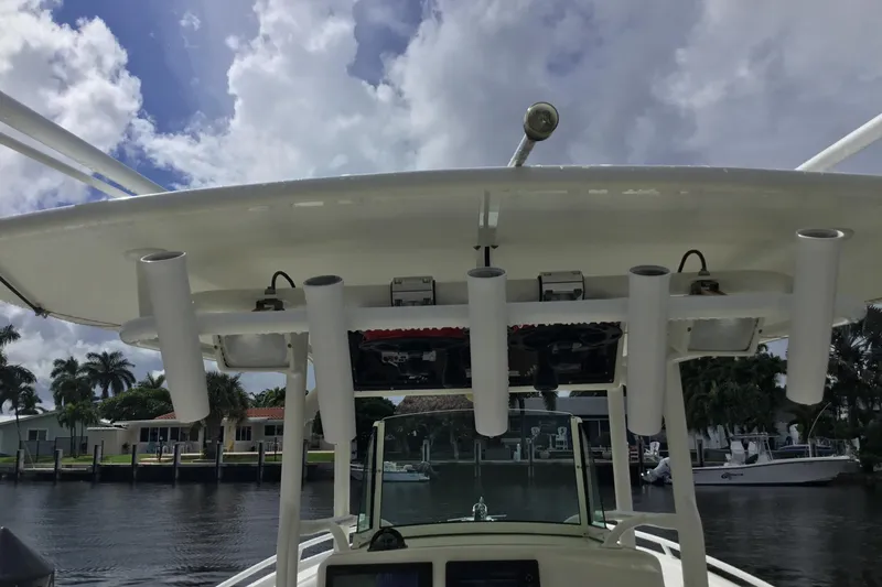Slide: The Image of 2016 Mako 284 Center Console boat with rod holders, docked near waterfront homes. - 27