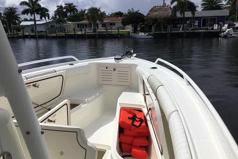 Slide: The Image of 2016 Mako 284 Center Console boat with life jackets, docked by waterfront homes. - 3