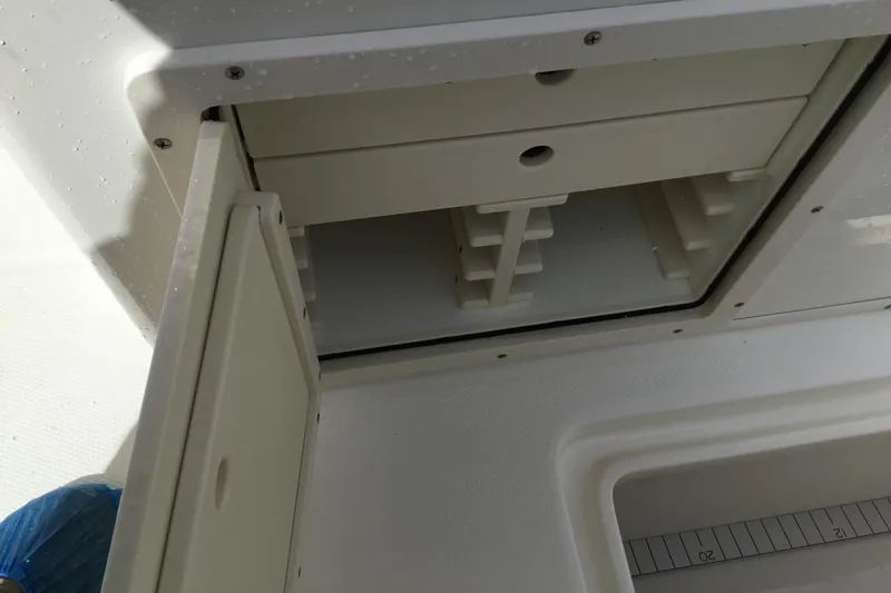 Slide: The Image of Open storage compartment on 2016 Mako 284 Center Console boat. - 32